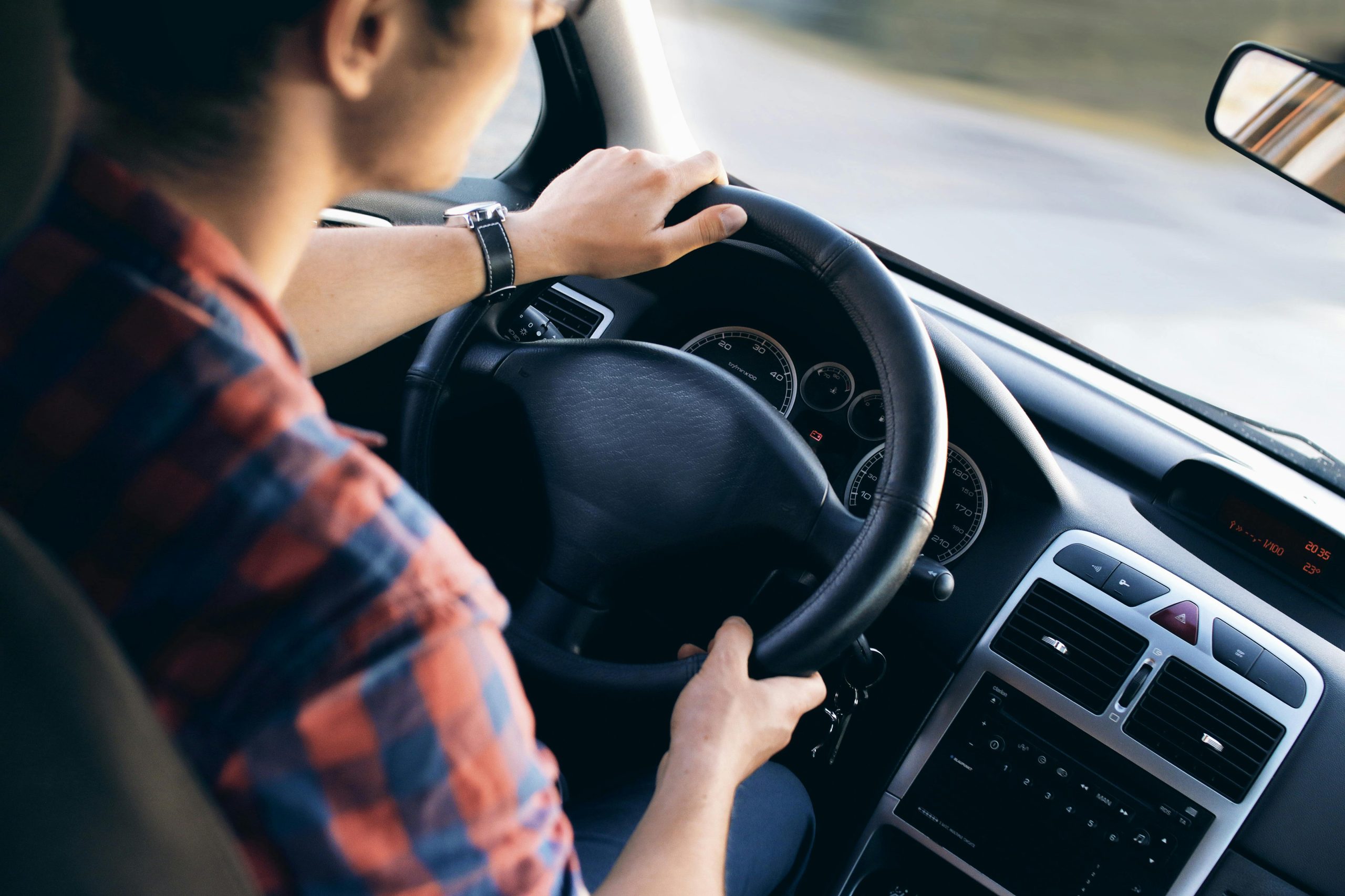 man driving with both hands on the steering wheel